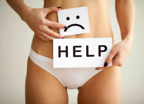デリケートゾーンの悩みを示す下腹部にHELPカードと悲しい顔のイラストを持った女性の写真